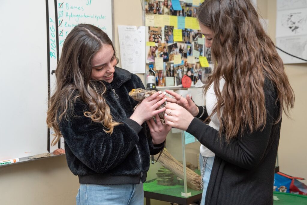 Girls holding iguana, animal therapy, New Haven Residential Treatment Center